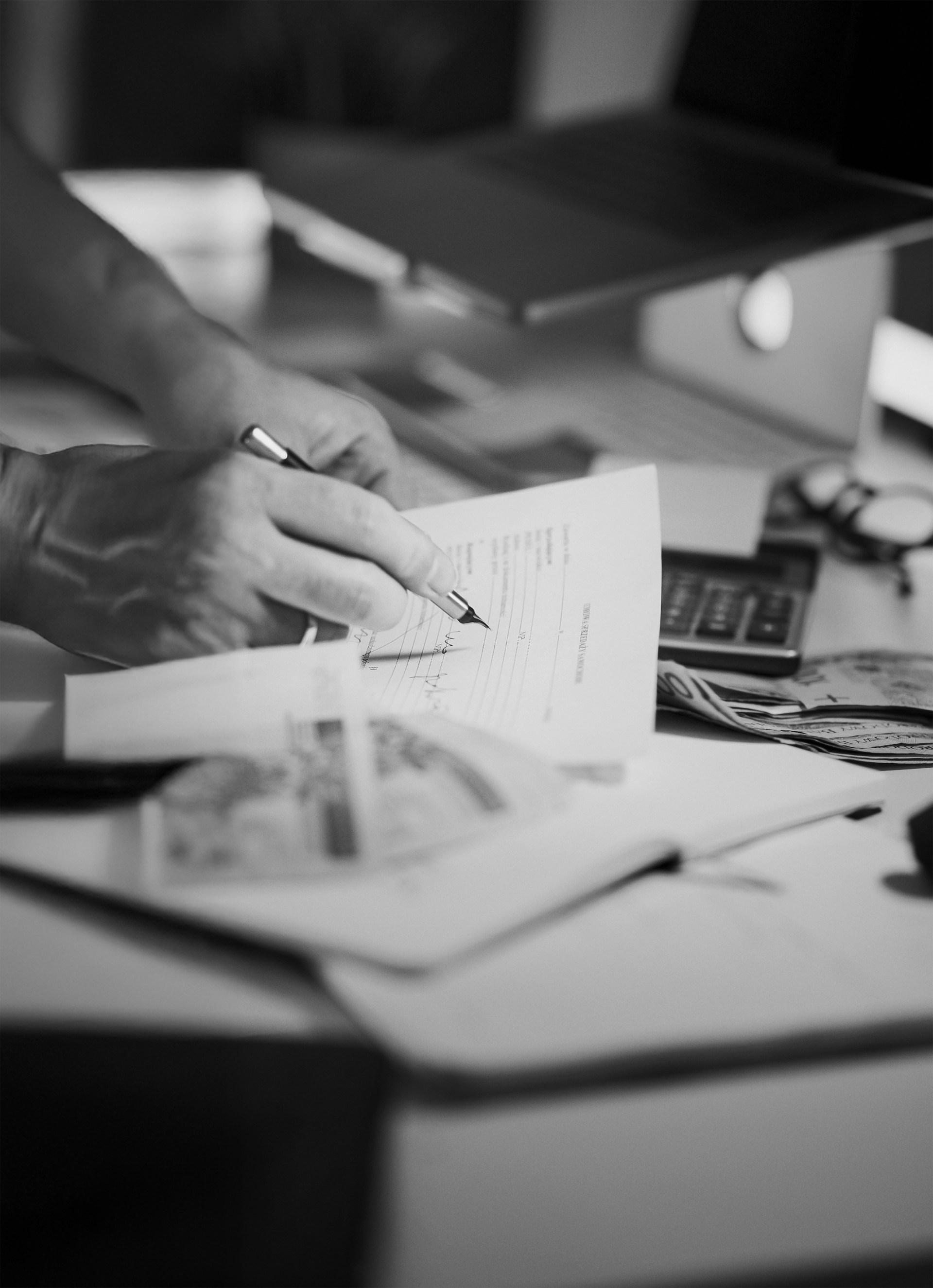 Hands signing a document at a desk